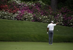 Tiger Woods takes a drop after hitting into a creek on the 12th hole. (AP)